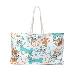 May include: White tote bag with a repeating pattern of cartoon dogs, paw prints, and bones in orange and teal. The bag has white rope handles.
