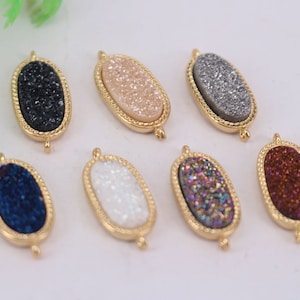 Puede incluir: Siete abalorios ovalados de metal dorado con piedras de ágata de diferentes colores. Las piedras son todas brillantes y tienen un aspecto moteado. Los abalorios tienen un bucle en la parte superior para sujetarlos a joyas.