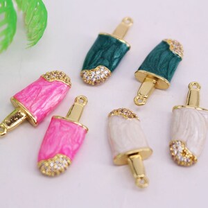 Puede incluir: Seis abalorios de paleta de helado de tono dorado con esmalte blanco, rosa y verde y detalles de diamantes de imitaci&oacute;n transparentes. Los abalorios tienen un bucle en la parte superior para sujetarlos a joyas.