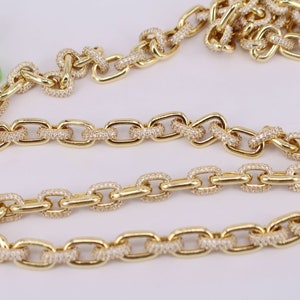 May include: Gold chain necklace with oval links, each link is encrusted with small clear stones.