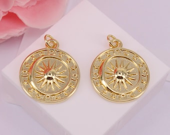 May include: Two gold-tone pendant charms featuring a sun with rays and a circle of stars around the edge.