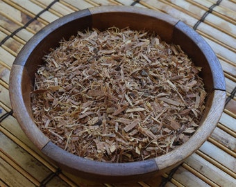 May include: A wooden bowl filled with dried, shredded bark. The bark is a light brown color and has a rough texture.