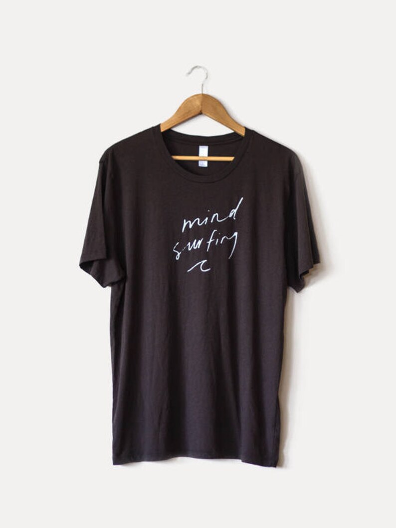 May include: A dark brown t-shirt with the text "mind surfing" written in white on the front.