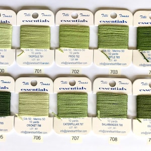 May include: A collection of 10 skeins of Tilli Tomas Essentials silk embroidery floss in shades of green. Each skein is labeled with the color name and number, such as "Inchworm 700" and "Tadpole 701".