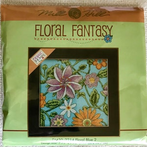 May include: Cross stitch pattern featuring a floral design with a blue background. The pattern is titled "Floral Fantasy" and is by Debbie Mumm. The design size is 7.7 inches by 17.7 inches.