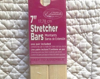 May include: A pair of 7 inch Frank A. Edmunds Co. wooden stretcher bars in a magenta cardboard header card. The packaging features white text stating Stretcher Bars, one pair included, and easy to assemble. The wooden bars are light tan.