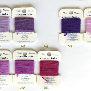 May include: Ten skeins of 10-yard silk embroidery floss in various shades of purple and pink. The skeins are labeled with the names "Sugar Plum", "Jelly", "Bettle Juice", "Butterfly", "Dragonfly", "Scarab", "June Bug", and the corresponding lot numbers.