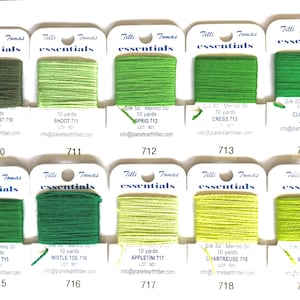 May include: A collection of ten spools of green embroidery thread, each labeled with a unique name and number. The thread colors range from dark forest green to light chartreuse. Each spool is labeled with the brand "Tilli Tomas essentials".