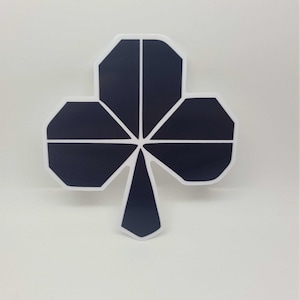 Op de afbeelding: Een zwarte en witte geometrische klaverontwerp sticker. De klaver is gemaakt van vijf punten en heeft een donkerblauwe kleur.