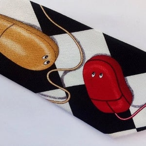 May include: A black and white checkered tie with two computer mice, one red and one gold, with eyes.