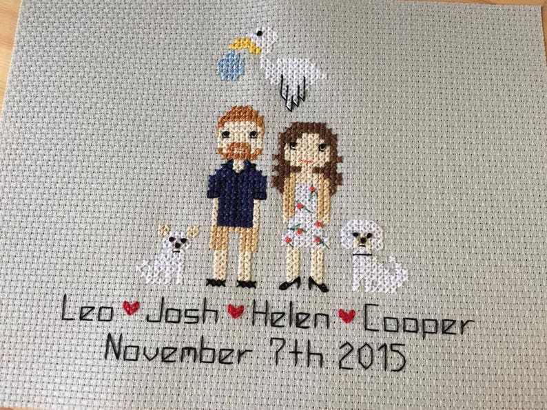 Puede incluir: Bordado de punto de cruz con una pareja, dos perros y una cig&uuml;e&ntilde;a con un beb&eacute;. El texto dice "Leo Josh Helen Cooper November 7th, 2015".