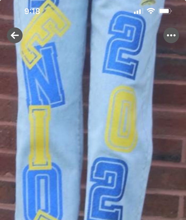 large, stylized lettering in blue glitter and yellow glitter htv. The letters appear to spell out senior class of 2026 which can be changed to any date Example 2027