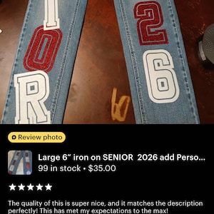 the word "SENIOR" and the number "2026" in red glitter and white glitter letters and numbers. The words are vertically aligned on the front of the jeans. "Class of" is written in cursive.