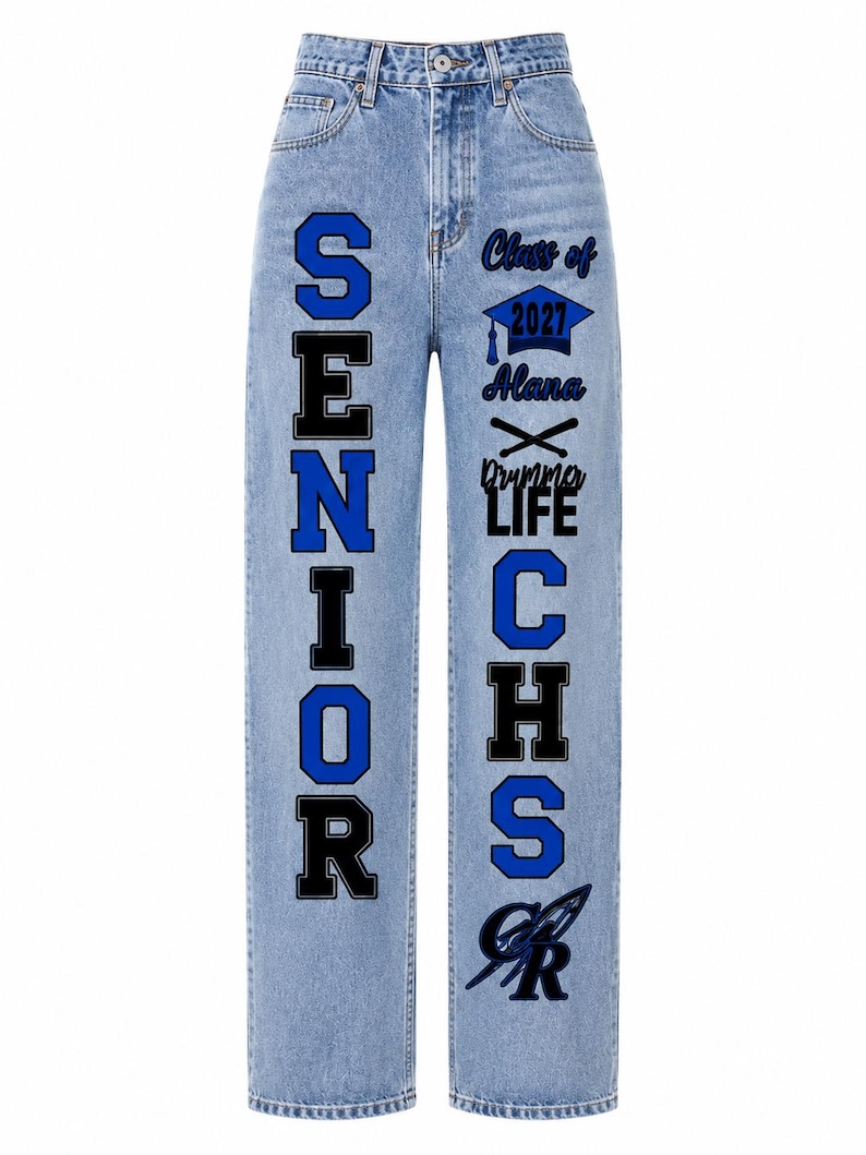 May include: Light blue denim jeans featuring a high waist and straight legs. The left leg displays the word SENIOR in large blue and black letters. The right leg features the text Class of 2027, Alana, Drummer LIFE, CHS, and a graphic logo.