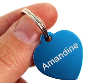 Medalla en forma de corazón en metal, con inscripción grabada con láser. Disponible en 2 tamaños y 8 colores, también sirve como llavero y bolso joya