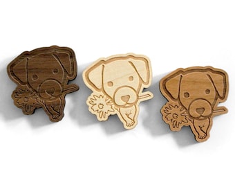 May include: Three wooden dog-shaped cutouts, each holding a flower in its mouth. The cutouts vary in color, from dark brown to light tan. The dog's features are etched into the wood, and the flower is detailed with delicate lines. These are likely decorative items.