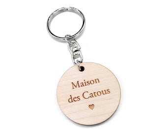 Keychain message. Small round wooden plaque engraved with your text and laser cut. Wood color and metal clip to choose.