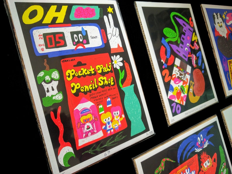 May include: A black and red illustration of a pencil shop with the text "Pocket Pals Pencil Shop" and the words "You can pose her in many ways! Three wriggly bits!"  The illustration features a green apple, a vase with a daisy, and a girl with a pink dress.