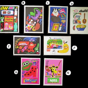 May include: A collection of eight colorful prints featuring various illustrations, including a cartoon character with a bubble gum, a giraffe with a pipe, a frog with a star, a vampire, a vending machine, a bowl of cereal, and a hand holding a pencil.