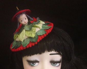 vintage doll face fascinator with velvet leaves fascinator with dolls head quirky red and green hat fruit with a face hat fun gay pride hat