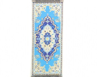 May include: A blue and gold patterned fabric hanging with a silver ornate frame and a blue evil eye charm.