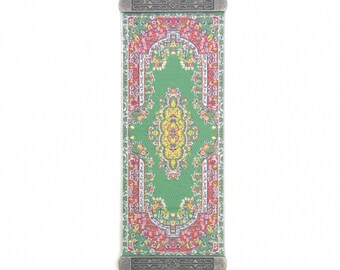 May include: A silver metal wall hanging with a green and red patterned fabric insert and a blue evil eye charm hanging from the bottom.
