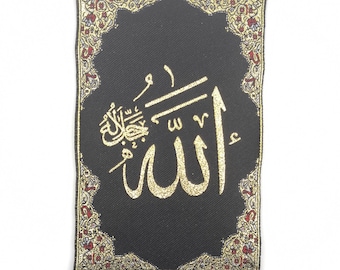 May include: A black fabric wall hanging with a gold embroidered Arabic calligraphy of the word "Allah" surrounded by a silver ornate frame. The hanging has a silver loop at the top and silver tassels with coin-shaped charms at the bottom.
