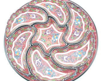 May include: A red ceramic serving dish with six compartments. The dish is decorated with a floral pattern in shades of blue, green, and white.