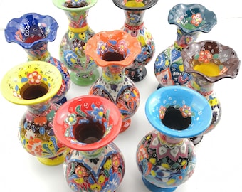 May include: A collection of eight colorful ceramic vases with floral patterns. The vases are all different shapes and sizes, and they are all decorated with intricate designs.