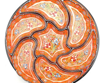 May include: A round orange ceramic serving dish with six sections. The dish is decorated with intricate floral patterns in shades of blue, red, and white.