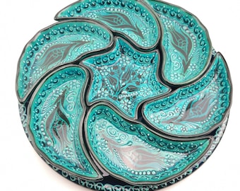 May include: A turquoise and black ceramic serving dish with six individual sections. The dish is decorated with a floral pattern.