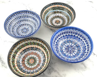 May include: Four ceramic bowls with intricate blue and white patterns. The bowls have a circular shape and are decorated with floral and geometric designs.