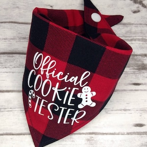 May include: Red and black buffalo plaid bandana with white text that reads "Official Cookie Tester" and a gingerbread man graphic.