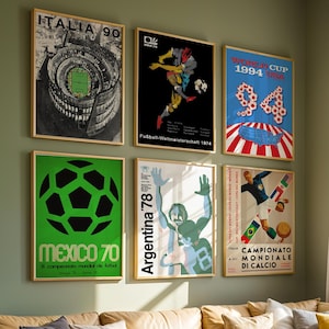 May include: A collection of six framed vintage soccer posters displayed on a wall. The prints feature iconic World Cup tournament graphics from 1970, 1974, 1978, 1990, and 1994, showcasing various artistic styles, bold typography, and soccer imagery.