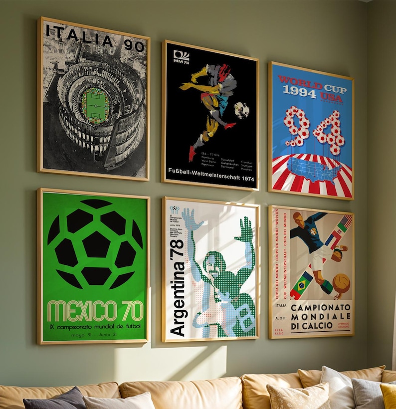 May include: A collection of six framed vintage soccer posters displayed on a wall. The prints feature iconic World Cup tournament graphics from 1970, 1974, 1978, 1990, and 1994, showcasing various artistic styles, bold typography, and soccer imagery.