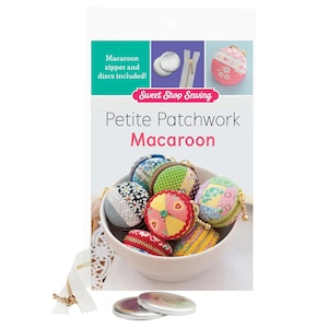 May include: A sewing pattern package titled Sweet Shop Sewing Petite Patchwork Macaroon. The packaging displays a white bowl filled with small, round, fabric-covered zippered pouches in various colorful patterns, along with metal discs and a zipper.