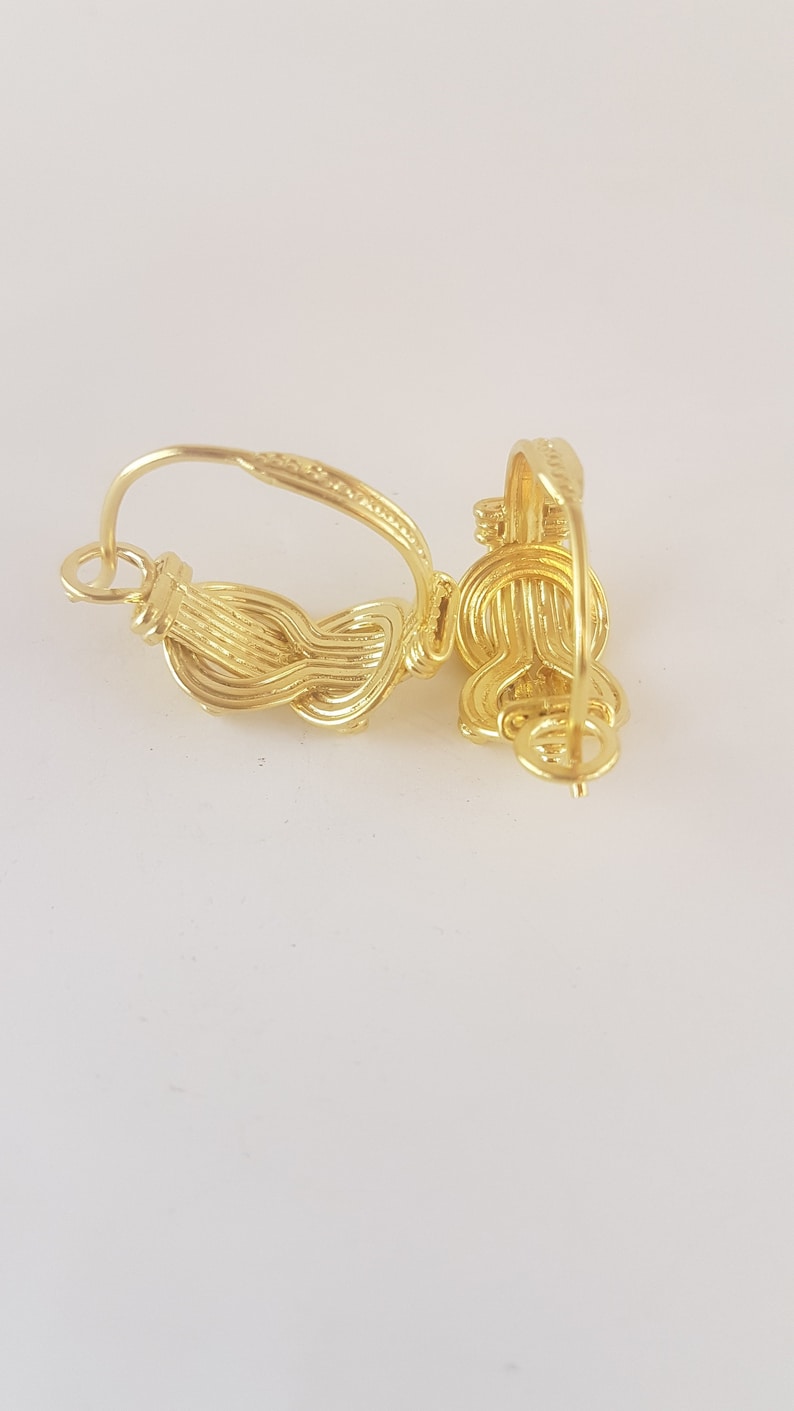 Op de afbeelding: Gouden creolen met een gedraaid draadontwerp. De oorbellen zijn gemaakt van &eacute;&eacute;n stuk draad dat is gedraaid en gelust om een uniek en ingewikkeld ontwerp te cre&euml;ren.