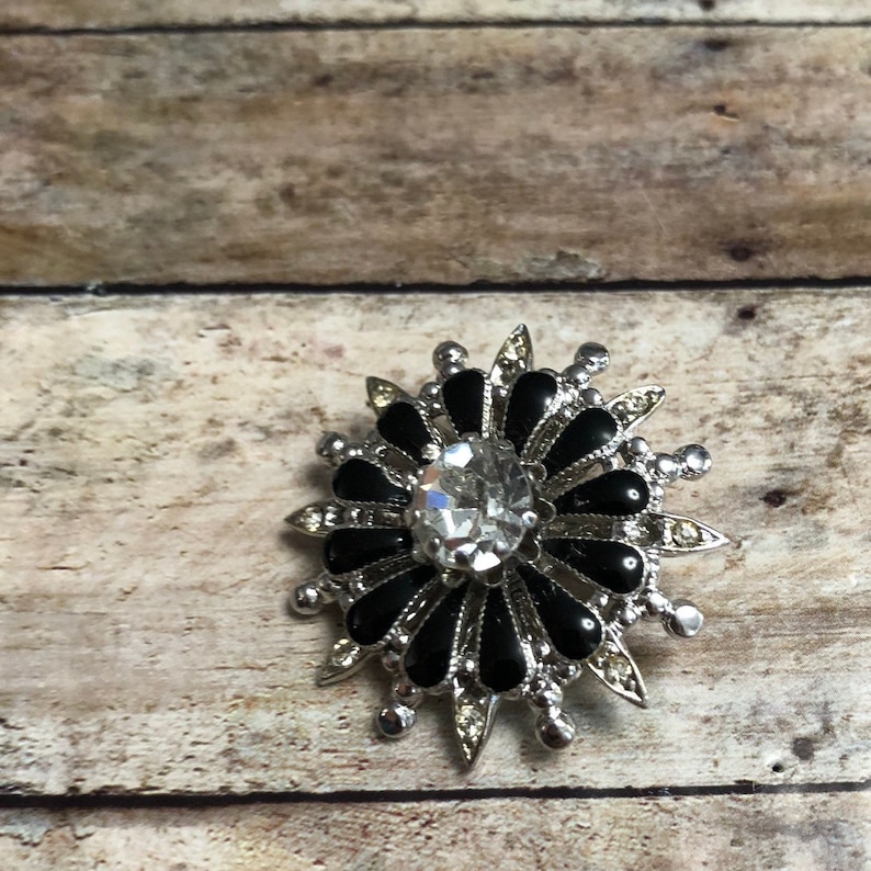 Coro vintage silver tone metal flower pin with black and clear crystals