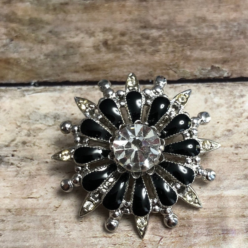 Coro vintage silver tone metal flower pin with black and clear crystals