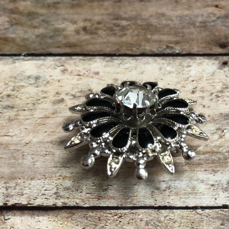 Coro vintage silver tone metal flower pin with black and clear crystals