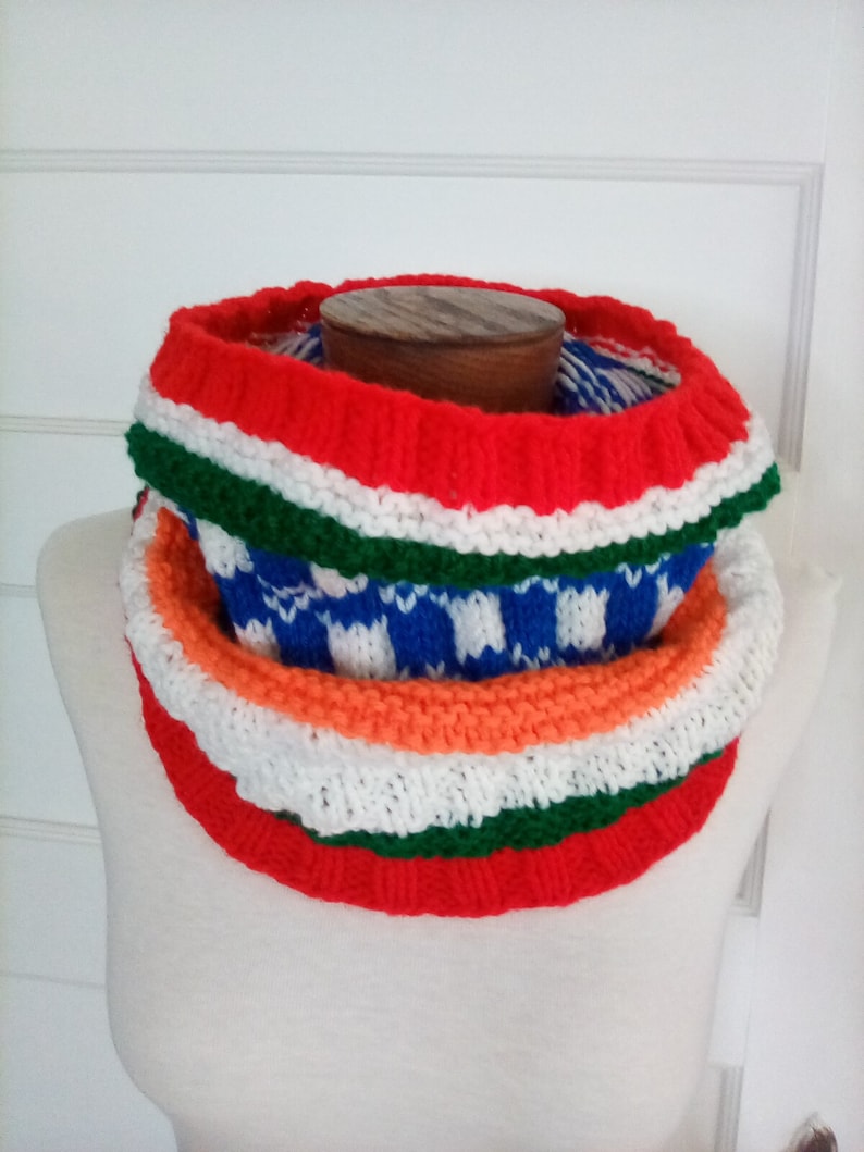 Peut inclure: Un chauffe-cou color&eacute; en tricot avec des rayures rouges, blanches, vertes, orange et bleues.
