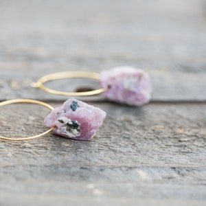 Peut inclure: Une paire de boucles d'oreilles cr&eacute;oles en or avec des accents de pierres pr&eacute;cieuses roses et noires.