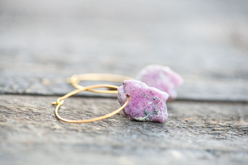 Peut inclure: Boucles d'oreilles cr&eacute;oles en or avec des accents de pierres pr&eacute;cieuses brutes roses et blanches.