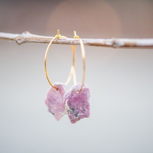 Peut inclure: Une paire de boucles d'oreilles cr&eacute;oles en or avec des accents de pierres pr&eacute;cieuses roses et blanches. Les boucles d'oreilles sont suspendues &agrave; une branche.