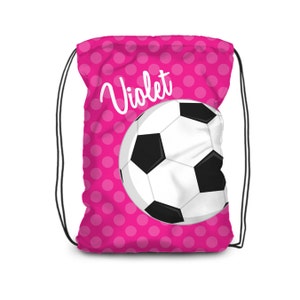 May include: Pink drawstring bag with white polka dots and a white soccer ball graphic. The bag has the name "Violet" written in white cursive.