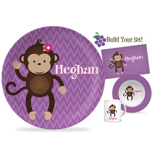 May include: Purple chevron patterned plate with a cartoon monkey wearing a pink flower. The plate says "Meghan" in a white cursive font.  Build Your Set! is written in black text on a white background.
