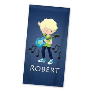 May include: A blue beach towel with a cartoon illustration of a boy with blonde hair playing a blue electric guitar. The towel has musical notes and the name "ROBERT" printed on it.
