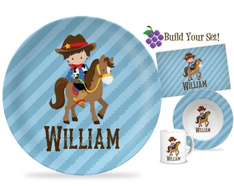 May include: A blue and white striped plate with a cartoon cowboy riding a brown horse. The plate has the name "William" written on it.  The plate is part of a personalized children's dinnerware set.