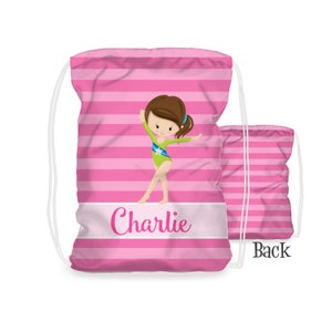 May include: Pink and white striped drawstring bag with a cartoon gymnast in a green leotard. The bag has the name "Charlie" printed on the front.