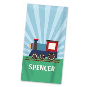 May include: A blue and red toy train with black wheels on a brown track against a blue and white striped background. The text "SPENCER" is printed in white on a green background.